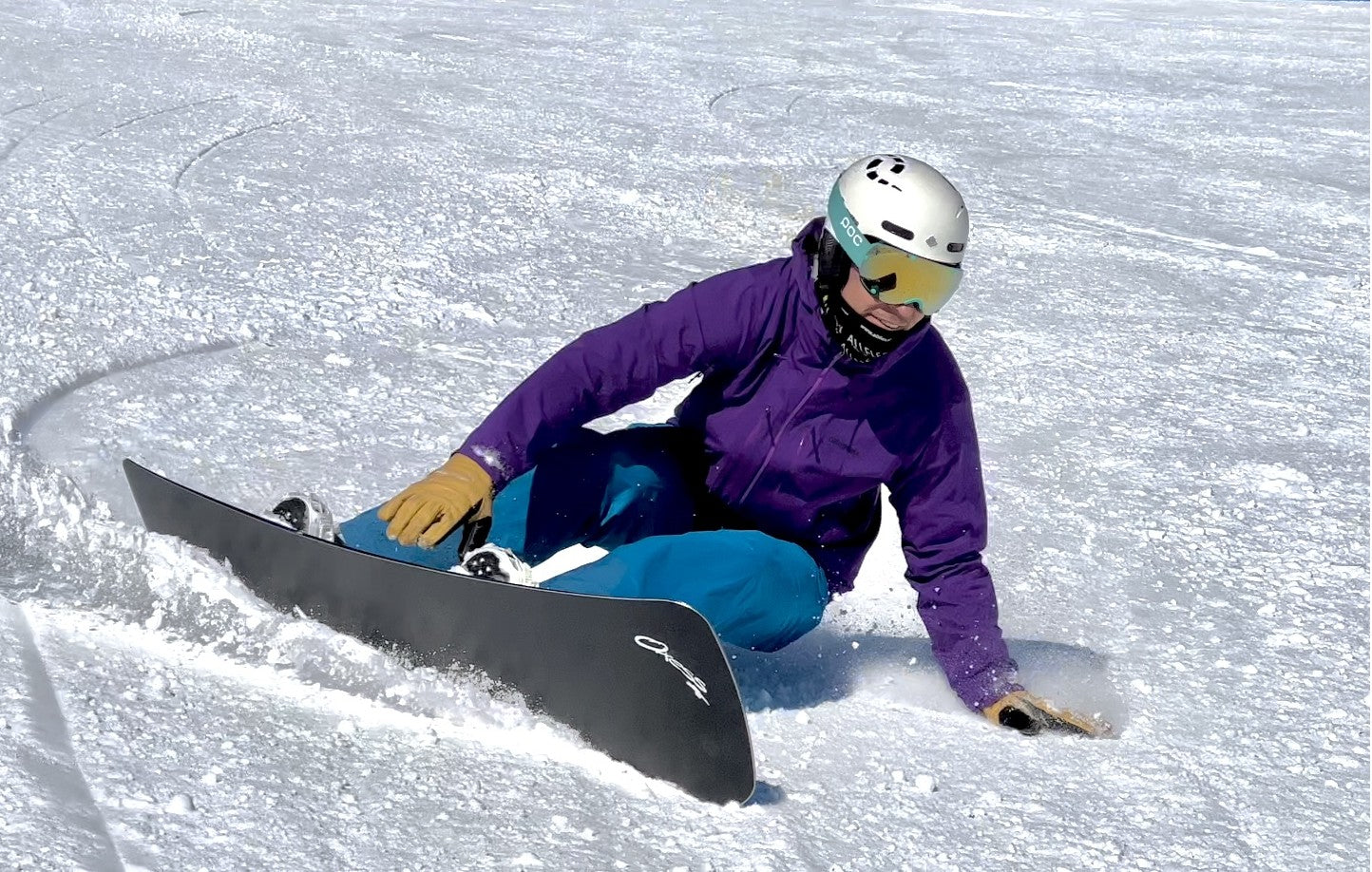 Rider carving on Oxess CX Pro snowboard – maximum grip, dampening, and precision turns.